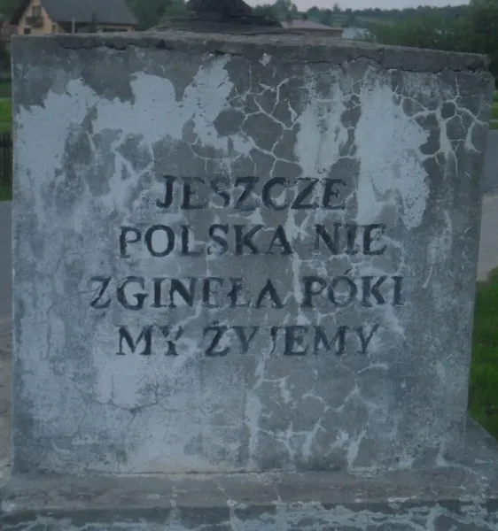 Dwór Sanna, kamienna ściana z tablicą